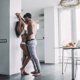 92186414-good-morning-young-romantic-couple-on-light-modern-kitchen-with-panoramic-sexy-young-woman-in-underw